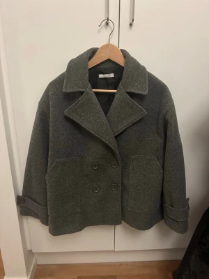 Jätte fin och skön kappa från design by si - Perfekt jacka till våren från design by si i storlek S/XS. Färgen är mörk grå. Inte så andvänd bara några få gånger.