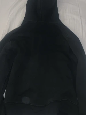 Svart hoodie från Polo Ralph Lauren - Säljer en svart hoodie från Polo Ralph Lauren med dragkedja och klassisk röd logga på bröstet. Hoodien har huva och två fickor framtill. Perfekt för en chill och stilren look. Strl 10-12 år gml