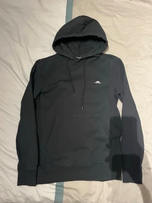 hoodie från J.Lindeberg - Snygg svart hoodie från J.Lindeberg med klassisk huva och dragsnören i storlek xs men passar även S (165-175)