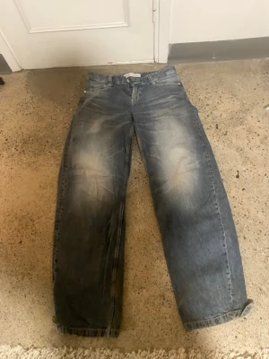 Baggy blå jeans  - Baggy jeans i blå denim med ljusa slitningar på låren och råa kanter vid bensluten. De är supersköna och säljs för att de inte kommer till användning längre. Jag är 168 cm lång och de passar perfekt på mig 