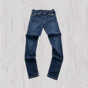 Tiger of Sweden blå jeans - Snygga blå jeans från Tiger of Sweden med klassisk femficksdesign och kontrastsömmar. Modellen har smal passform och är tillverkad i italienskt premiumdenim. Perfekt för dig som gillar stilrena och moderna jeans med lite edge.