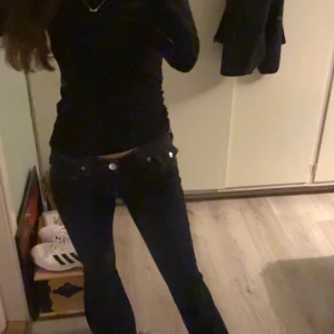 Mörkblå lågmidjade jeans, true religion  - Snygga mörkblå jeans med låg midja och klassisk femficksdesign. Jeansen har en rak passform och är tillverkade i ett stretchigt denimtyg som sitter bekvämt. Perfekta för dig som gillar en enkel och stilren look.