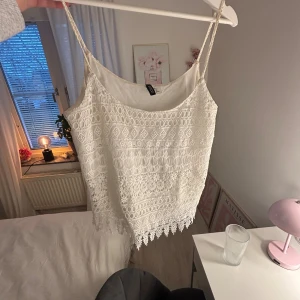 Vit spetsig linnetopp från Gina Tricot - Superfin vit linnetopp från Gina Tricot med tunna axelband och detaljerad spets över hela toppen. Toppen har ett vackert mönster och avslutas med dekorativ spetskant nedtill. Säljer pga av att den är för stor❣️