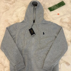 Grå hoodie från polo ralph lauren - Snygg polo ralph lauren kofta som är helt oanvänd utan prislapp.