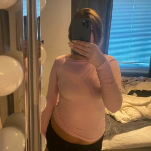 Ljusrosa långärmad topp - Säljer en enkel och stilren ljusrosa långärmad topp i mjukt bomullsmaterial. Modellen är figurnära med rund halsringning och passar perfekt till jeans eller kjol. Superskön och lätt att matcha med andra plagg.