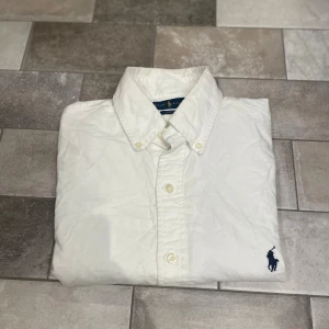 Vit Ralph Lauren Skjorta - En stilren Skjorta från märket Ralph Lauren. Intresserad? Skriv privat pris kan diskuteras 