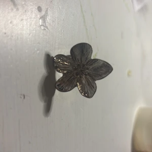 Stor silverfärgad blomring - Säljer en statementring i silverfärg med en stor, detaljerad blomma som motiv. Ringen har justerbar storlek och blommans yta har fina ådringar som ger en cool och unik look. Perfekt för dig som vill sticka ut med accessoarer!