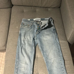 Ljusblå jeans Type 688 från Jacob Cohen - Snygga ljusblå jeans från Jacob Cohen, modell Type 688. Klassisk femficksdesign med gröna broderade detaljer på fickorna och insidan av gylfen. Knappar i metall med logotyp och unikt broderat citat. Jeansen har en rak passform och är tillverkade i mjukt bomullsjeansmaterial.köp idag för 750