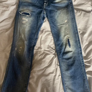 Blåa Jacob Cohen Jeans - Säljer ett or blåa Jacob Cohen jeans. De är slim fit me sköna slitningar å en unik knapp. W29 L 30