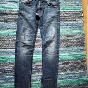  Nudie Jeans - Snygga blå jeans från Nudie Jeans i modellen thin fin. Jeansen har ett hål och ett lagat se på bilderna. Vid frågor bara höra av sig