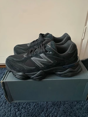 Svarta New Balance sneakers - Säljer ett par svarta New Balance sneakers med chunky sula och mesh-paneler. Skorna har snörning och detaljer i mocka och syntet, samt en stor N-logga på sidan. Perfekt för dig som gillar sportig stil och vill ha bekväma skor med cool design.