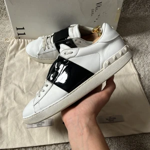Valentino open skor - Valentino Garavani Open skor! Box, 2st dustbags och kort medföljer vid köp av skorna!  Skick: fint skick annars men slitna på sulan och inuti. Färg: vita skor med svart lackerad rand. Nypris: 8500kr. Mitt pris är endast 1600kr!