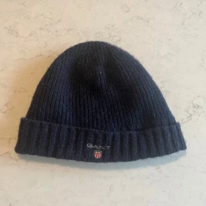 Mörkblå Gant mössa  - Mörkblå gant mössa med uppvikt kant, super varm och go till vintern! 