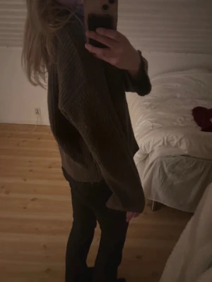 Brun stickad kofta med dragkedja - Mysig brun stickad kofta med lång ärm och dragkedja framtill. Koftan har en loose passform och är perfekt för kyliga dagar. Ribbad struktur och hög krage ger en chill och avslappnad vibe. Passar dig som gillar enkla och bekväma plagg.