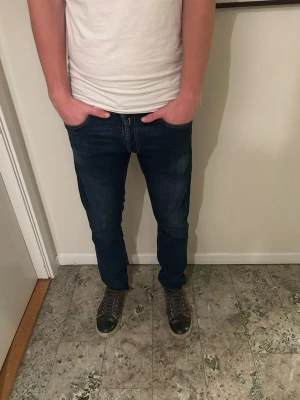 Replay jeans  - Säljer ett par replay jeans i mörkblå tvätt med klassisk femficksdesign och smal passform. Jeansen har normal midja och är tillverkade i slitstarkt bomullsmaterial med lite stretch för extra komfort. Perfekt för dig som gillar en clean och modern look.