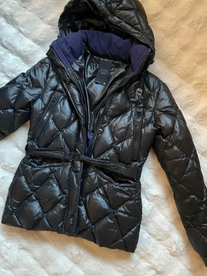 Svart quiltad pufferjacka G-Star RAW - Säljer en svart quiltad pufferjacka från G-Star RAW. Jackan har huva, bälte i midjan och flera dragkedjefickor. Väldigt bra skick och supersnygg! Står M på lappen men är mer som en S!