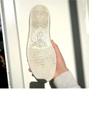 Gucci Ace sneakers med tigerpatch - Säljer ett par vita Gucci Ace sneakers i skinn med ikonisk grön och röd sidoremsa och broderad tigerpatch. Baksidan har metallicröd detalj med ormmönster och Gucci-logga. Klassisk platt sula och snörning framtill. Perfekta för dig som vill sticka ut.