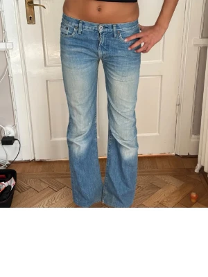 Replay bootcut jeans ljusblå - Säljer ett par replay  jeans i ljusblå tvätt med bootcut passform.  Materialet är slitstarkt jeans och modellen har en lågmidjad siluett som ger en avslappnad vibe. Finns ett igensatt hål mellan benen (syns på bilden) men det är inget hål längre lappningen  syns däremot .