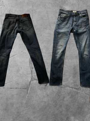 Blå jeans från Tiger of Sweden - Säljer ett par klassiska blå jeans från Tiger of Sweden med snygg tvätt och raka ben. Jeansen har fem fickor, orangea sömmar och knappstängning fram. Materialet är slitstarkt denim och passformen är normal med straight cut.