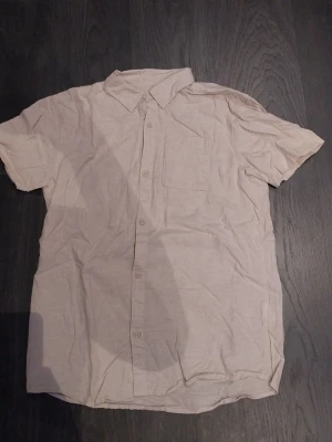Beige kortärmad skjorta - Säljer nu denna kortärmadeskjortan ifrån cubus då den är för liten. Den är riktig somrig och fin. Den har endast använts 1 gång. 