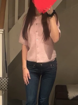 Ljusrosa kofta från Gina Tricot - Superfin ljusrosa kofta från Gina Tricot. Kort ärm, rund hals och knappar framtill. Ribbstickad och mjuk, perfekt att slänga över en topp för en söt look. Passar dig som gillar en lite loose fit och vill ha något mysigt men ändå stilrent. Pris kan diskuteras