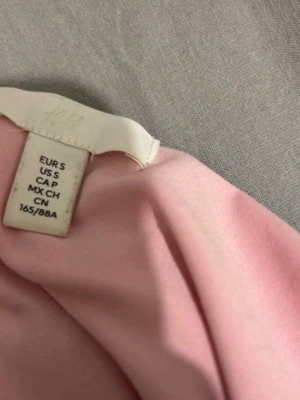 Ljusrosa offshoulder topp H&M - Söt ljusrosa offshoulder topp från H&M i mjukt material. Toppen har en axelbandslös design och sitter tight mot kroppen, perfekt för sommaren. Har inte använt den så mycket eftersom den inte passar min hudton så mycket. 