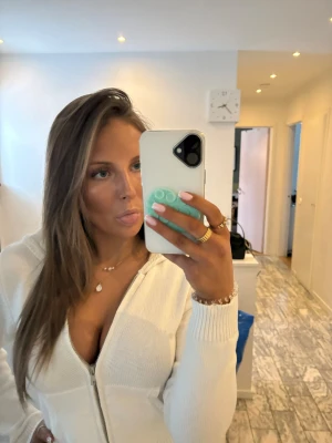 Vit ribbad zip hoodie - Snygg vit hoodie med dragkedja och ribbade muddar. Tröjan har en figurnära passform och är tillverkad i ett mjukt, stickat material. Perfekt för en avslappnad och trendig look.