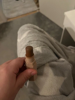 Fenty Beauty Match Stix bronzer - Säljer en Fenty Beauty Match Stix bronzer i en krämig stickform. Färgen är en djup brun ton, perfekt för contouring eller värme till ansiktet. Förpackningen är sexkantig och beige med vit text. Enkel att applicera och smälter snyggt in i huden. Använd endast 2 gånger då ja inte tyckte om den på min hud
