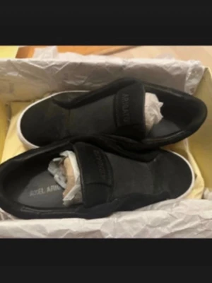 Svarta sneakers från Axel Arigato - Säljer ett par svarta slip-on sneakers från Axel Arigato, då de är förstora på mig.  Skorna är i mocka. 