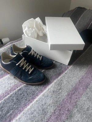 Maison Margiela gats - Maison Margiela i mörkblå mocka och skinn med beige snörning och gummisula. Storlek 43 | användna fast i gott skick | skriv vid minsta funderingar 