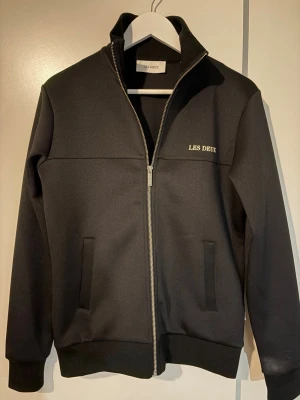 Svart ziptröja från Les Deux - Svart fullzip från Les Duex i storlek xs, är själv 174. Köpt ifrån Les Duex egna hemsida. I helhet är tröjan knappt använt. 