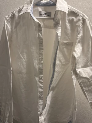 Vit skjorta från Hampton Republic barn storlek 146 - Klassisk vit skjorta från Hampton Republic med lång ärm och bröstficka. Skjortan har knappar framtill och en stilren krage. 