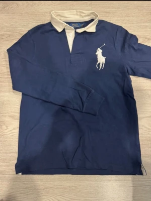Big Pony Långärmad Piké - Mycket fin långärmad pikétröja från märket Ralph Lauren. Även kallad rugbytröja. Fungerar både som en skön tröja men även vid ett finare tillfälle tack vare den skjortaktiga kragen.                   Pris kan diskuteras vid snabb affär