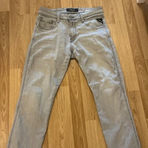 Replay ljusgrå jeans slim fit - Storlek W30/L32 köptes för 1000kr Snygga ljusgrå jeans från Replay med klassisk femficksdesign och raka ben. Jeansen har diskreta sömmar och logga på bakfickan. Perfekta för dig som gillar en clean och stilren look. Materialet är mjukt och stretchigt för extra komfort. 