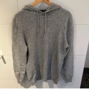 Stickad hoodie - En grå stickad Hoodie från dressman, tröjan är nästan som hel ny och är väldigt svår att få tag på. Storlek M 
