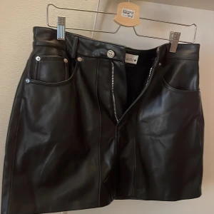 Skinnkjol  - Snygg svart kort skinnkjol från Zara med dragkedja.  fickor både fram och bak. Kjolen är super snygg och går att använda både till vardags men också till när man vill vara lite extra snygg! Materialet är mjukt och i skinn. Hör av er för föer bilder!