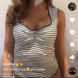 Randig Zara  top  - Snygg top med svartvita ränder och twistad detalj framtill. Modellen har breda axelband och en djup urringning som ger en modern look. Materialet känns mjukt och stretchigt. Svarta kantdetaljer runt hals och ärmhål ger extra kontrast.