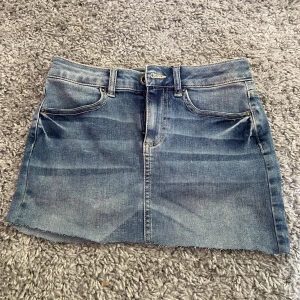 Jeanskjol från Pieces XS - Säljer vidare pga fel storlek!💓 Säljer en klassisk blå jeanskjol från Pieces i storlek XS. Kjolen är kort, har rå kant nertill, fem fickor och bälteshällor. Perfekt för dig som gillar en enkel och tidlös denimlook. Passar till allt och är superenkel att styla. Den är även low waist