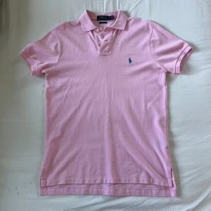 Ralph Lauren pike - Riktigt snygg polo ralph lauren pike i den klassiska rosa färgen. Tröjan är i bra skick och ser bättre ut i verkligheten än på bilderna. 
