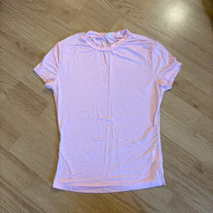 Ljusrosa basic t-shirt XS - En enkel och mjuk ljusrosa t-shirt i klassisk modell med rund hals och korta ärmar. Perfekt att matcha med jeans eller kjol för en chill look. Tillverkad i skönt bomullsmaterial som andas.