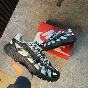 Nike P-6000 shadow grey  - Nike P-6000 sneakers i svart och vitt med coolt rutigt meshmönster och svarta detaljer. Skorna har snörning, platt sula och rund tå. Ovandelen är i syntet och mesh för en sportig vibe. Perfekta för dig som gillar streetstyle och vill sticka ut med en unik look. Aldrig använda.