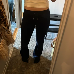 Marinblå mjukisbyxor Juicy Couture XS - Mysiga marinblå mjukisbyxor från Juicy Couture i storlek XS. Byxorna har bootcut-modell, snörning i midjan och är gjorda i mjuk velour med lite stretch. Perfekta för chill dagar eller när du vill vara extra comfy.