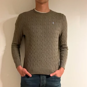 Morris kabelstickad tröja  - En brun kabelstickad Morris tröja i merinoull i storleken L (L/M). Nypris: 1899kr. Vårt pris: 449kr.  Modellen är 190cm och väger 81kg. Hör av er vid frågor/fler bilder!