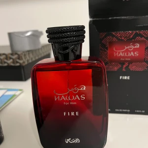Hawas Fire For Him parfym 100ml - Hawas Fire For Him från Rasasi är en Eau de Parfum i en snygg röd glasflaska med svart kork och detaljer. Flaskan rymmer 100 ml och har en modern, fyrkantig design. Doften är maskulin och intensiv, perfekt för dig som gillar att sticka ut. Enbart testsprutad!