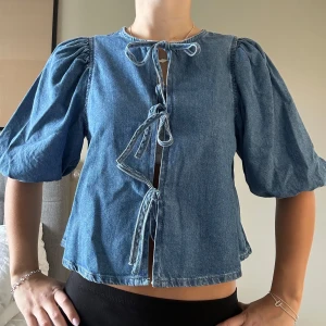 Jeans topp med puffärm  - Cool jeanstopp med puffärm och knyt framtill. Helt ny och aldrig använd, dock är lappen avtagen. Tryck inte på KÖP DIREKT utan skriv privat om du är intresserad! 💛