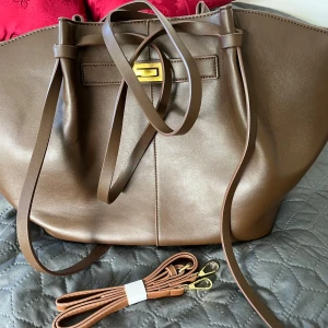 Brun axelväska i skinn med snörning -  bra skick, original pris 500kr