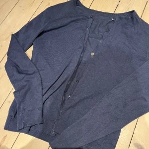 Mörkblå kofta med knappar - Mörkblå kofta med rund hals och långa ärmar. Stängs med små knappar framtill. Tunn och mjuk, perfekt att slänga över en t-shirt. Saknar tre knappar men försöka hitta liknande och så på dem om det önskas! 💕
