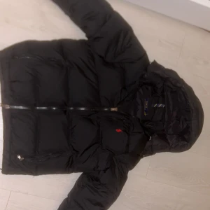 Svart dunjacka från Polo Ralph Lauren - Svart Ralph lauren jacka i superbra skick. Använd ett fåtal gånger. Pris kan diskuteras i dm