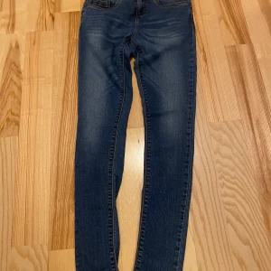 Push Up Push In skinny jeans blå - Mörkblå skinny jeans med push up push in-effekt. Klassisk femficksmodell med snygga slitningar och kontrastsömmar. Jeansen är tillverkade i stretchigt denim för en tight och bekväm passform.