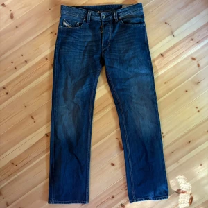 Diesel Larkee jeans blå W30 L30 - Säljer ett par klassiska blå Diesel Larkee jeans med raka ben och normal passform. Jeansen har fem fickor, snygga sömmar och en mörkblå tvätt. Perfekta för dig som gillar en tidlös look och vill ha ett par jeans som funkar till allt.